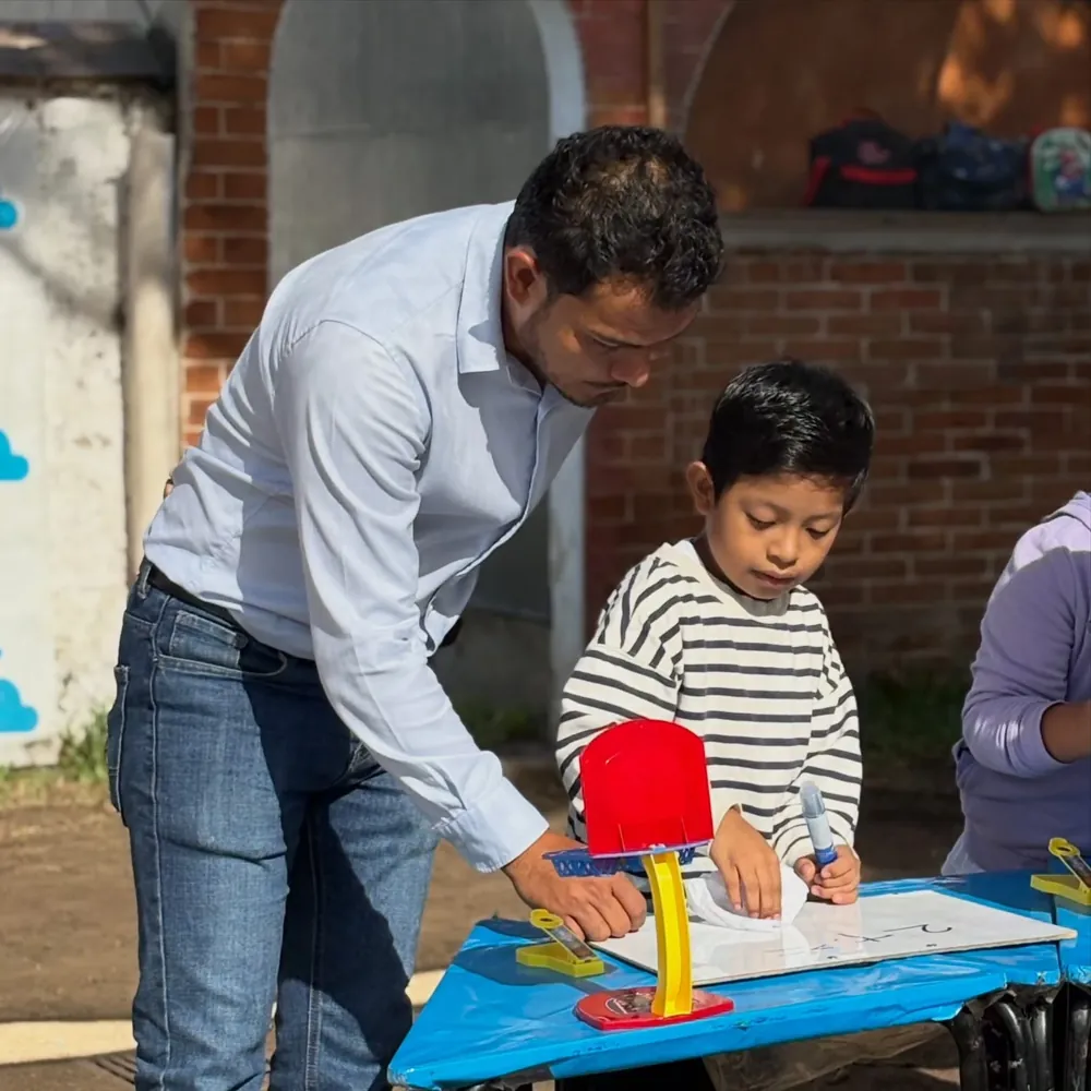 Papá acompañando a su hijo en una actividad de escritura durante las Aulas abiertas de Kiddies Club